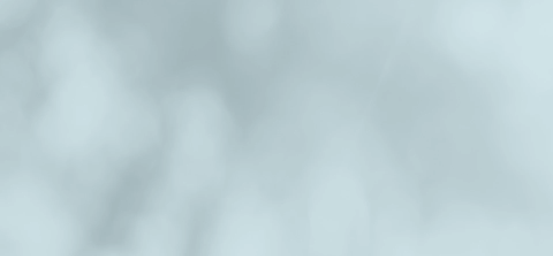 Soft, blurry light blue and white abstract background with gentle gradients and bokeh effect.